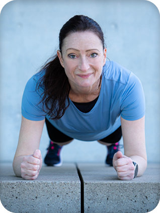 Coach doing a plank exercise and looking into the camera.